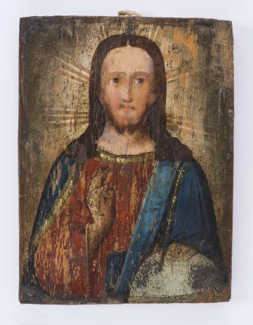 Obraz-ikona na desce prostokątnej drewnianej. Przedstawia w półpostaci Chrystusa na ciemnym tle, rozjaśnionym wokół głowy nimbem ze srebrzystymi promieniami. Prawa dłoń uniesiona do błogosławieństwa, lewa wsparta na półkul (globie) w kolorze srebrzysto-błękitnym. Twarz jasna, z długim wąskim nosem, ciemnobłękitnymi oczami, wąską brodą okoloną ciemnym, krótkim zarostem. Włosy ciemnobrązowe opadające na ramiona. Chrystus ubrany w ciemnoczerwoną suknię z żółtym oblamowaniem przy dekolcie i ciemnobłękitny płaszcz, również z żółtym oblamowaniem krawędzi. Niedomalowane obrzeża obrazu oraz resztki gwoździ wskazują, iż ikona była oprawiona w ramę. Farba na powierzchni, miejscami zniszczona. 