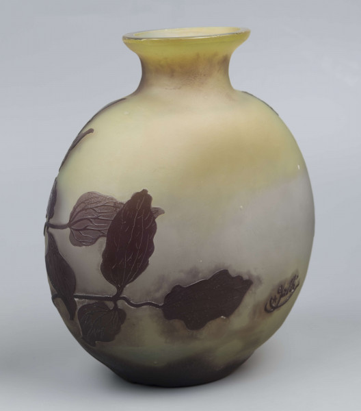 S/CS/1378/ML - Wazon w formie kuli pionowo spłąszczonej z krótką szyją i owalnym wylewem, szeroko wywiniętym, z płasko sciętym brzegiem; ze szkła bezbarwnego, matowionego, przy dnie i przy szyi barwionego na kolor żółty i fioletowobrunatny. Na powierzchni plastyczny wzór swobodnie rzuconej gałązki klematisu z kwiatami w kolorze fioletowobrunatnym.
 