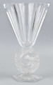 S/CS/1681/ML - Wazon w formie kielicha ze szkła bezbarwnego grubościennego; na sześciobocznej fasetowanej podstawie, trzon zdobiony plastycznie i matowiony w formie owalnego wieńca, wewnątrz którego siedzą dwa ptaszki - kolibry; czara koniczna fasetowana sześciobocznie z płaską krawędzią.
 