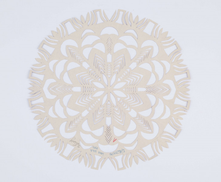 Wycinanka kolista z glansowanego wiśniowego papieru. Ornament geometryczno-roślinny. Środek wycinanki wypełnia ośmiopłatkowy stylizowany kwiat o śred. 13,5 cm o ażurowych płatkach. Motyw otoczony ażurowym ornamentem złożonym z falistych linii i stylizowanych płatków. Zewnętrzny okrąg wycinanki składa się ze stylizowanych wielopłatkowych kwiatków i ażurowych elementów prostokątnych.  