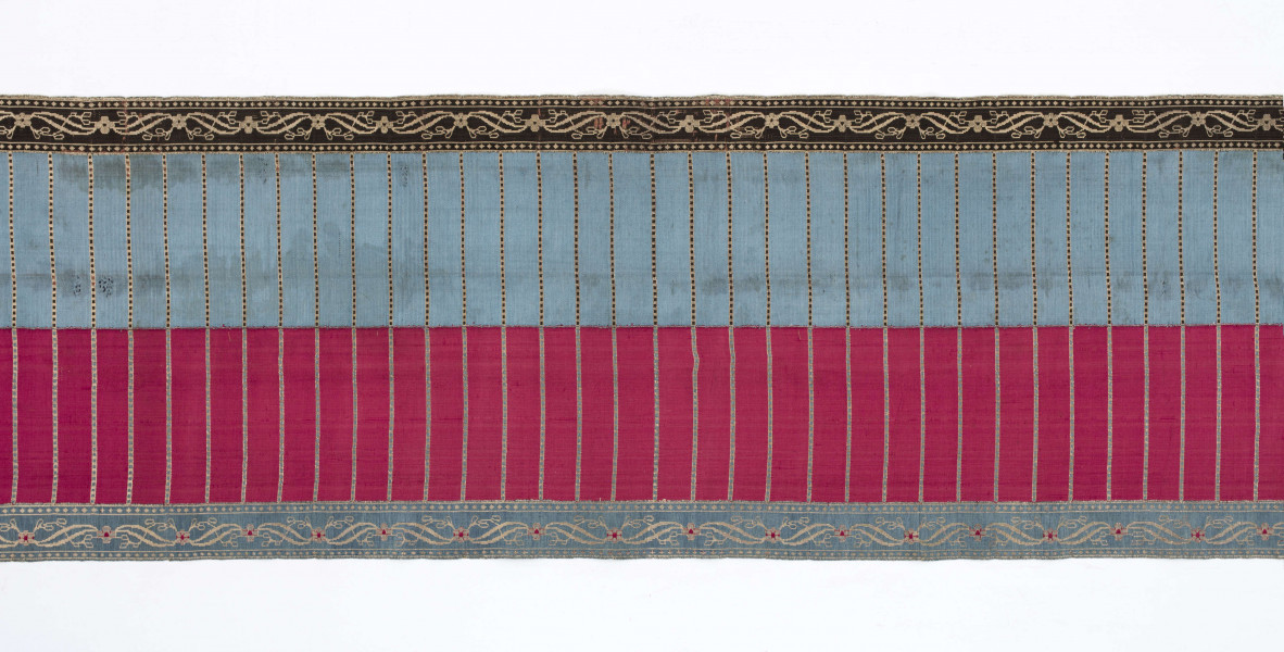 Pas kontuszowy 4-stronny
Ornament:
głowy - dwa krzaczki kwiatowe otoczone medalionami z wijącej się wstęgi
środek ( wciąż)- poprzeczne gładkie pólka
obwódki - z motywem kostki i rombów
obrzeżenia pionowe z motywem podwójnej przeplatającej się wici roślinnej, poziome - z motywem wijacej sie wstążki z kwiatami
Kolor:
pr. - tło głów i obrzeżeń srebrne, ornament brązowy z błękitem i amarantem, pólka w połowie brązowe (czarne ?), w połowie kremowe
l. - tło połowy głów i obrzeżeń błękitne oraz  w połowie pólek amarantowe, druga połowa głów i obrzeżeń brązowa oraz pólek - amarantowa
W narożnikach sygnatura wytkana 