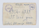 ML/H/F/19/1 - Na fotografii pozuje 16 dziewcząt - uczennic gimnazjum. Ubrane sa w stroje ludowe: pasiaste spódnice, kamizelki, korale. Niektóre mają na głowach wianki z kwiatów. Stoją na chodniku przed budynkiem na tle czarnych, zakończonych łukiem drzwi. 
Fotografia wykonana z okazji 35. lecia Gimnazjum H. Czarnieckiej w Lublinie.