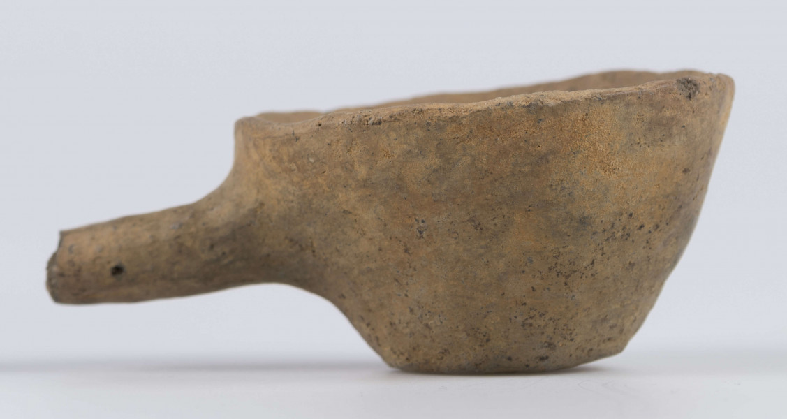 1702/A/ML - dno płaskie, ścianki proste, wylew zawinięty do wewnątrz; krawędź zaokrąglona; pod krawędzią umieszczono trzymadełko prostopadłe do ścianki, o przekroju owalnym, ułamane