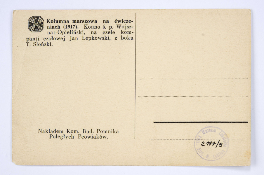 Pocztówka sepiowana - kolumna marszowa Polskiej Organizacji Wojskowej na ćwiczeniach (zdjęcie w plenerze). Ujęcie w poziomie.
AWERS: kolumna osób w mundurach wojskowych i ubraniach cywilnych na drodze; na czele  postać w mundurze, po lwej stronie jeden z peowiaków konno, na lewo od niego mężczyzna w mundurze stojący półprofilem; w tle zabudowania ogrodzone płotem. 
REWERS: czarna linatura z miejscem na korespondencje; w l. g. rogu nadruk w postaci odznaki pamiątkowej 