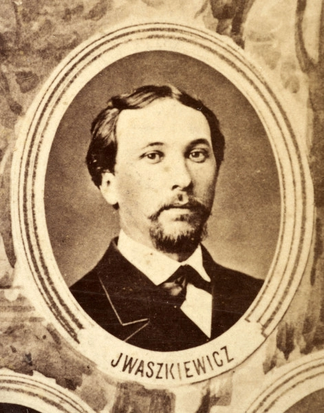 Fotografie w odcieniu sepii umieszczone na tle drzew i roślin, w centralnym miejscu postać kobiety ze sztandarem i aniołkami, wkomponowane widoki budowanej stacji, mostu kolejowego i lokomotywy. Największe zdjęcie w górnej, środkowej części bez podpisu, prawdopodobnie inż. głównej kolei nadwiślańskiej Tadeusz Chrzanowski lub jego następca Walery Titkow. Wśród podobizn pracownicy Biura Głównego Inżyniera: inż. Włodzimierz Stanisławski - pomocnik głównego inżyniera; inż. Feliks Kucharzewski -  pomocnik naczelnika biura; Feliks Kamocki - naczelnik kancelarii; Witold Lanci - naczelnik Wydz. Architektury; dr Wacław Lasocki- służba zdrowia; Władysław Radwan - sprawy zakupu gruntów; inż. Stanisław hr Scipio - projektant mostów kolejowych i jego współpracownicy: inż. Stefan Zieliński, inż. Maurycy Machalski, inż. Feliks Kucharzewski. Fotografia w passe - partout, za szkłem, oprawiona w drewnianą, profilowaną ramę.