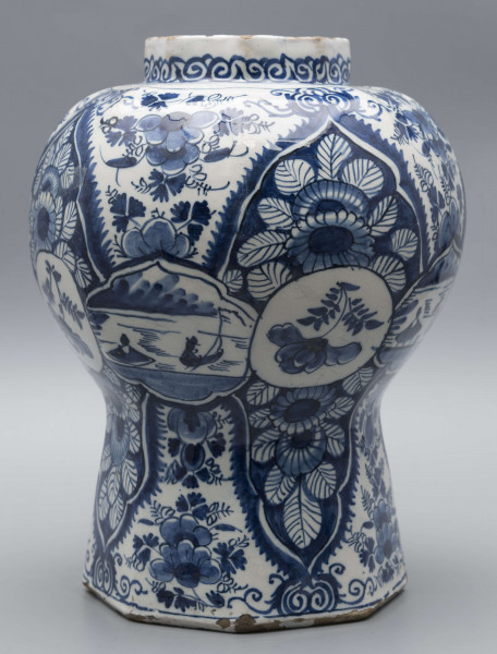 S/CS/1516/ML - Wazon balasowy z wysoka podstawą, wybrzuszonym korpusem i krótką szyją, ośmioboczny, o podziale zaznaczonym na całej wysokości. Czerep kremowy, szkliwo białe, dekoracja malowana podszkliwnie ciemnobłękitnym kobaltem. Na całej powierzchni regularnie rozmieszczony wzór lambrekinowy z motywami dużych kwiatów na błękitnym tle, przedzielony partiami białego tła z błękitnymi kwiatami. W dolnej części korpusu białe zezerwy z dekoracja naprzemienną: kwiatowa i figuralną – silnie uproszczone sylwetki ludzi w pejzażu. Na szyi fryz wolutowy.
 