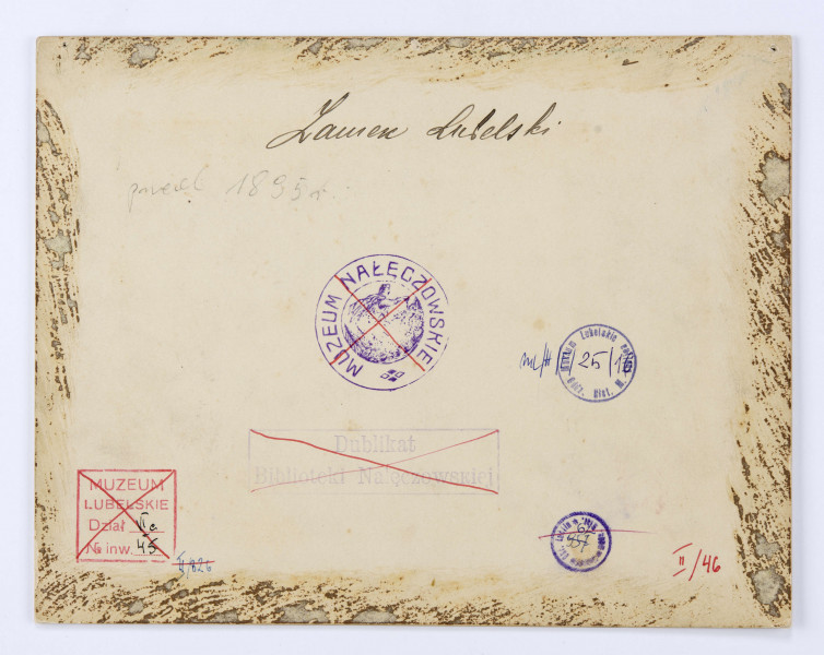 Widok Wzgórza Zamkowego i dzielnicy żydowskiej od strony południowo-zachodniej przed 1895 r. Ujęcie ze skarpy Wzgórza Staromiejskiego. Z lewej strony widoczne ogrodzone drewnianym płotem zabudowania dawnego kościoła i klasztoru św. Wojciecha przy ul. Podwale. Na utwardzonym placu przed budynkami stoją ludzie. Za osobnym ogrodzeniem skład desek. Po prawej stronie rozległy zielony teren ze stogiem siana. Na drugim planie gęsta zabudowa dzielnicy żydowskiej, więzienie na zamku z widocznym szczytem kaplicy Św. Trójcy i otynkowaną basztą (donżonem). Przy północnej ścianie zamku widoczny fragment synagogi Maharszala. Na lewo, na Wzgórzu Czwartek kościół Św. Mikołaja. 

Fotografia sepiowana, naklejona na tekturę, otoczona ramką w kolorze złotym w formie przecinających się na rogach listew. W l. d. rogu nazwisko autora fotografii, w p. d. nazwa miasta. Na rewersie odbitki pieczęci tuszowych Muzeum Nałęczowskiego (okrągła, w kolorze fioletowym) oraz Biblioteki Nałęczowskiej (podłużna, w kolorze fioletowym). Przy górnej krawędzi napis informacyjny czarnym tuszem z odręcznym dopiskiem ołówkiem.
