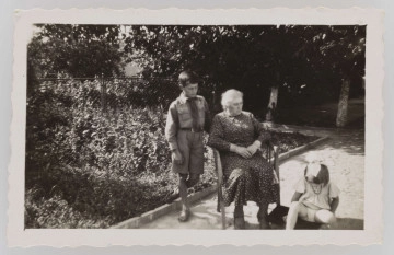 ML/MART/1513 ML/MART/1513 - Fotografia Jerzego Lewińskiego (z lewej) w mundurku harcerskim, w środku starsza kobieta siedząca na fotelu, po prawej siedząca dziewczynka. Fotografia zrobiona w ogrodzie na tyłach domu.