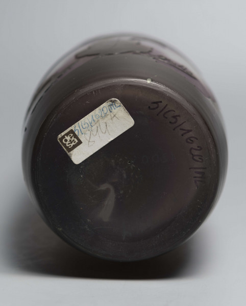 S/CS/1620/ML - Wazon o kształcie wrzecionowatym ze szkła grubościennego, matowego, bezbarwnego,  podbarwionego od dołu fioletem, od góry błękitem. Powlekany warstwą liliową i brązowooliwkową; w niej trawiona i polerowana dekoracja roślinna: swobodnie rozmieszczone gałązki werbeny z kwiatami.
 