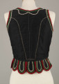 E/16876/ML - Gorset zszyty z 6 kawałków czarnej satyny, podszyty lnianą podszewką. Z przodu rozcięcie usztywnione fiszbinami oraz haftkami do przewlekania wstążeczki. Od pasa dookoła opadają klapki „taszki”. Przód wzdłuż rozcięcie wycięcie wokół szyi, brzegi pach i taszki ozdobione czerwoną, zieloną i białą wełnianą krepinką. Plecy zdobione ornamentem wykonanym ściegiem krzyżykowym. Szyty ręcznie.