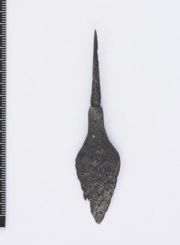 Grot strzały kształtu liście, ostrze łagodnie przechodzące w czworoboczny trzpień, który w dalszej części jest w przekroju okrągły, ostro zakończony o dużo mniejszej średnicy niż część czworoboczna