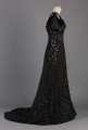 S/T/243/ML - Suknia wizytowa, czarna, uszyta z atłasu jedwabnego, jedwabnego tiulu i aksamitu, haftowana cekinami. Krótki rękaw z jedwabnego czarnego aksamitu, dekolt prostokatny, dość głęboki, wykończony wstawką haftowaną i aksamitem. Kolory są kontrastowe. Spodnia warstwa sukni, z białej tafty i muślinu, widoczna w partiach sukni szytych z czarnego tiulu, dodaje całości elegancji. Brzegi dekoracyjnej wici z tafty zaakcentowane naszytymi cekinami. Suknia do ziemi z tyłu krótki tren. Brak halki. 