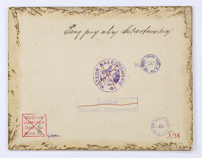 Widok placu targowego przy ulicy Świętoduskiej. Ujęcie od strony odcinka dawnej ulicy Nowej (dzisiejszej Lubartowskiej). Po lewej stronie widoczny kościół karmelitów oraz zabudowa kamienic. Pośrodku plac wypełniony ludźmi i konnymi furmankami. W centralnej części prowizoryczny budynek ze spadzistym jasnym dachem. W głębi po prawej murowany pawilon z kramami. W oddali widoczny kościół i szpital Jana Bożego oraz ówczesny folwark Czechówka.
 
Fotografia sepiowana, naklejona na tekturę, otoczona ozdobną ramką w kolorze złotym w formie przecinających się na rogach listew. W l. d. rogu nazwisko autora fotografii, w p. d. nazwa miasta. Na rewersie odbitki pieczęci tuszowych Muzeum Nałęczowskiego (okrągła, w kolorze fioletowym) oraz Biblioteki Nałęczowskiej (podłużna, w kolorze fioletowym). Przy górnej krawędzi napis informacyjny czarnym tuszem.
