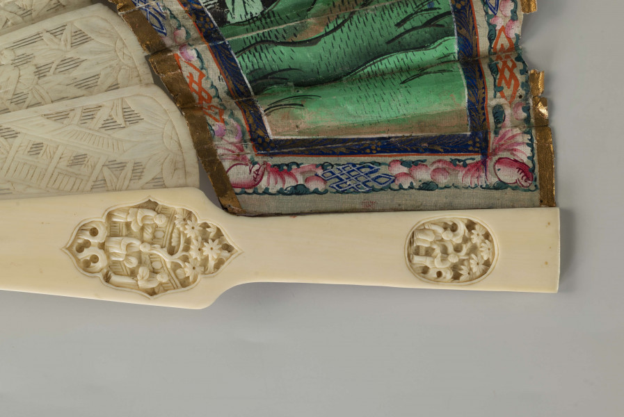 S/R/68/ML - Wachlarz rozkładany. Pokrycie asymetryczne, dwustronne, malowane gwaszem. Twarze postaci wykonane z malowanych, naklejanych, płytek kości słoniowej, ich stroje z malowanych kawałków tkaniny jedwabnej również naklejanych na papier pokrycia. Na wachlarzu przedstawiono sceny rodzajowe w charakterystycznej perspektywie (widziane nieco z góry) w kompozycji kontynuacyjnej, przedstawiają dworzan w towarzystwie wysokiego urzędnika, w scenerii pałacowego ogrodu z pawilonami. Barwne stroje z jedwabiu nawiązują do dworskiej mody i są niezwykle zróżnicowane.   Podkreślone są różnice w formie i detalu stroju. Urzędowe nakrycie głowy, foutou, wyróżnia jedną z przedstawionych postaci, cesarza (?). Stelaż z kości słoniowej, rzeźbiony w motywy roślinne i figuralne, pióra okładzinowe gładkie. Zdobią je pojedyncze, owalne, rzeźbione kompozycje, medaliony ze scenami figuralnymi. Pierścień mosiężny spina stelaż.