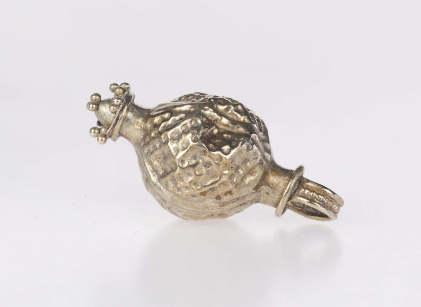 Wisiorek kulisty, typ Ia (wg. klasyfikacji A. v. Müllera). Korpus zdobiony czterema pionowymi żeberkami i wybijanymi punkcikami, wypełniającymi liniami w układzie skośnym pola pomiędzy nimi. Wieszadełko składające sie z szyjki przylegającej bezpośrednio do kuli, wieńczącego ją pierścienia i uszka taśmy z pogrubionym brzegiem z polem między nimi wypełnionym granulacją. Na dole wisiorka znajduje się element w postaci tulejki z przylutowanym stożkiem umieszczonym na profilowanej płyce, której narożniki, jak i szczyt stożka, zdobią triady granulek. Wisiorek prawdopodobnie był importem z terenów kultury wielbarskiej.
Wymiary dodatkowe: 2,5 mm (śr. szyjki wieszadełka); 2,5 mm (wys. szyjki wieszadełka); 4,0 mm (śr. pierścienia wieszadełka); 2,0 mm (szer. uszka); 2,0 mm (śr. tulejki); 1,5 mm (wys. stożka)