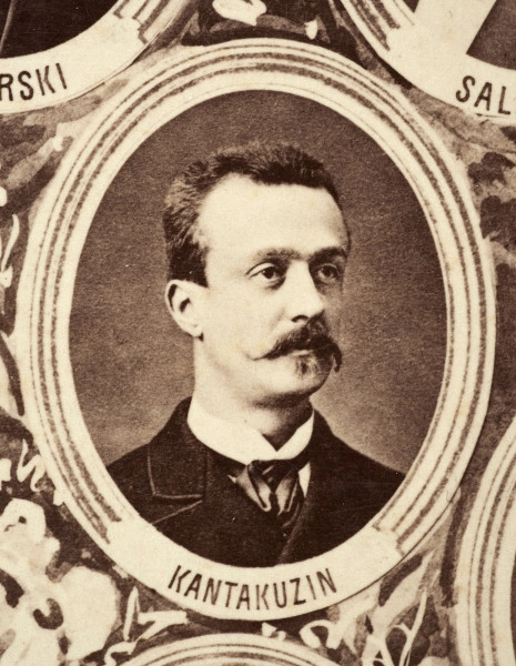 Fotografie w odcieniu sepii umieszczone na tle drzew i roślin, w centralnym miejscu postać kobiety ze sztandarem i aniołkami, wkomponowane widoki budowanej stacji, mostu kolejowego i lokomotywy. Największe zdjęcie w górnej, środkowej części bez podpisu, prawdopodobnie inż. głównej kolei nadwiślańskiej Tadeusz Chrzanowski lub jego następca Walery Titkow. Wśród podobizn pracownicy Biura Głównego Inżyniera: inż. Włodzimierz Stanisławski - pomocnik głównego inżyniera; inż. Feliks Kucharzewski -  pomocnik naczelnika biura; Feliks Kamocki - naczelnik kancelarii; Witold Lanci - naczelnik Wydz. Architektury; dr Wacław Lasocki- służba zdrowia; Władysław Radwan - sprawy zakupu gruntów; inż. Stanisław hr Scipio - projektant mostów kolejowych i jego współpracownicy: inż. Stefan Zieliński, inż. Maurycy Machalski, inż. Feliks Kucharzewski. Fotografia w passe - partout, za szkłem, oprawiona w drewnianą, profilowaną ramę.