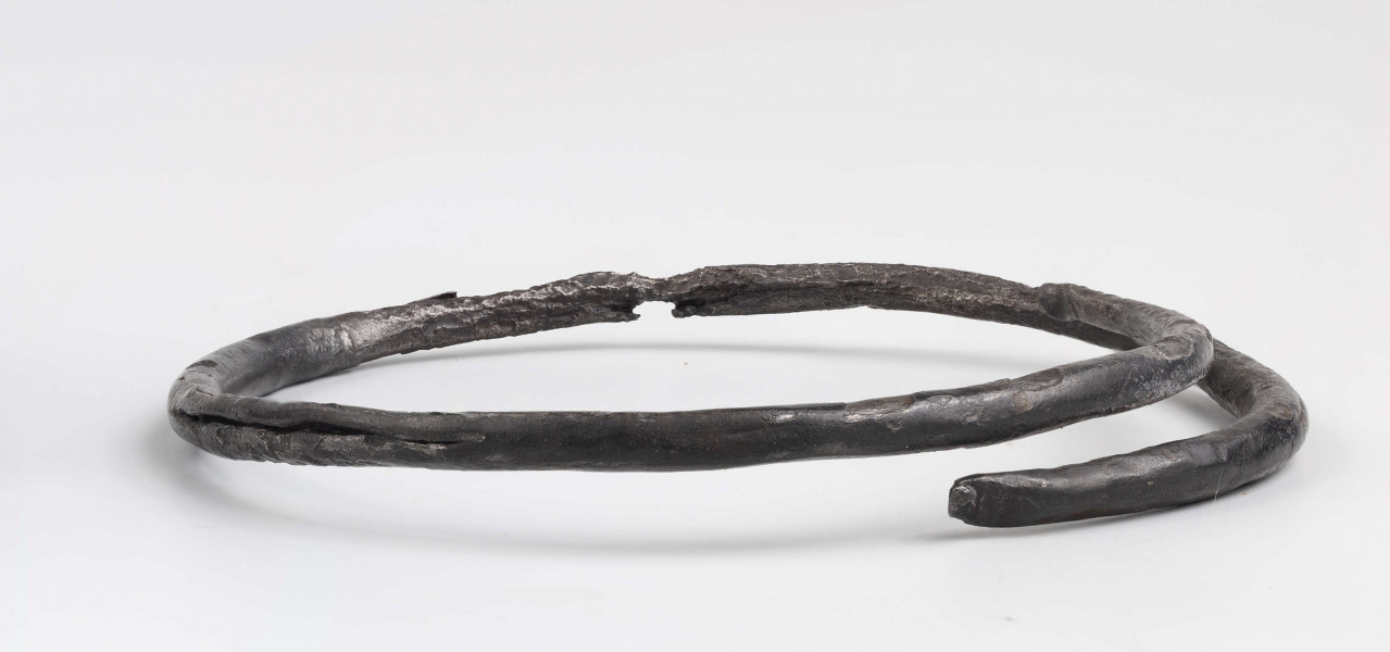 Bransoleta żelazna, w przekroju okrągła; końce zwężające się, szpiczasto zakończone, rozklepane, zwinięte