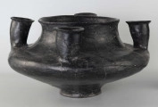 598/A/ML - naczynie kultowe (kernos) kultury pomorskiej; 
wymiary dodatkowe: 25,0 cm - średnica centralnego wylewu
opis: naczynie wazowate o czarnej, błyszczącej powierzchni, którego brzusiec został ozdobiony ornamentem złożonym z linii rytych oraz nakłuć; wokół głównego otworu posiada cztery symetrycznie rozmieszczone kielichy-rytony, które mają nieco wydęte ścianki boczne i kielichowato rozchylone na zewnątrz krawędzie otworów; rytony łączą się z głównym otworem kanalikami; 