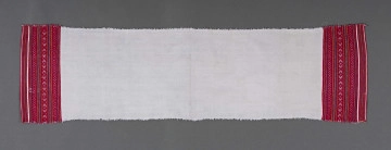 Ręcznik z samodziałowego płótna tkanego splotem prostym. Brzegi dolne, na szer. 14,5 cm, ozdobione ornamentem tkackim zw. pereborami. Ułożony pasowo, złożone z motywów geometrycznych w postaci rombów, kształtów litery X oraz drobnych prążków, w kolorze niebieskim, pomarańczowym i czerwonym.