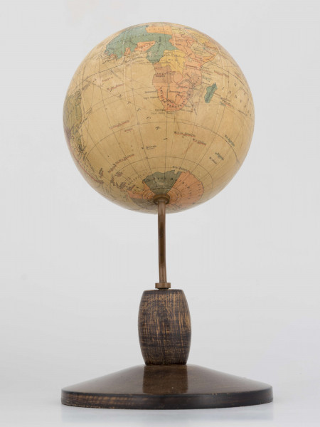 Mały polityczny globus Ziemi z polską nomenklaturą w skali 1:100 mln. Litografia kolorowa; 12 segmentów i 2 koła. Globus zamontowany na ramieniu drucianym, model 