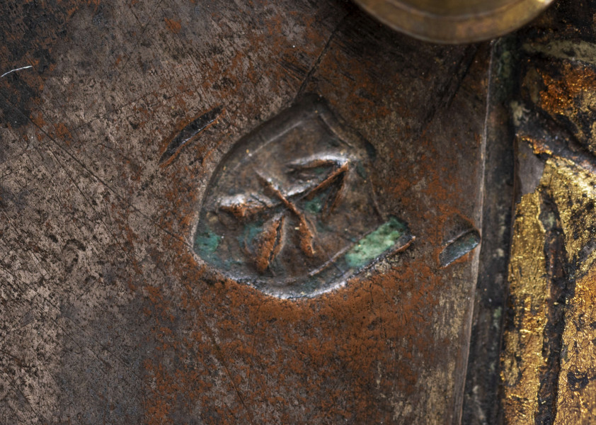 Portret trumienny męski z przedstawieniem nieznanego szlachcica herbu Lubicz. Pole obrazowe w kształcie nieforemnego sześciokąta. Ujęcie portretowanego od strony prawej, w zwrocie 3/4 do widza. Na neutralnym, srebrzonym tle - realistyczne przedstawienie szlachcica. Twarz potraktowana portretowo, ramiona płaszczyznowo zarysowane. Przedstawiony mężczyzna w średnim wieku, w typie sarmackim - długie wąsy, podgolone włosy, ubrany w czarny żupan spięty pod szyją czerwono-ugrowym guzem; widoczny fragment kołnierza białej koszuli. Twarz malowana laserunkowo, z próbą oddania cech charakterologicznych, pociągła. Długi, prosty nos, małe, lekko przymknięte oczy. Po prawej stronie herb szlachecki. W czerwonym polu tarczy herbowej - godło - srebrna podkowa zwrócona ocelami do dołu, pośrodku niej - srebrny krzyż kawalerski. Nad tarczą korona szlachecka z klejnotami w postaci trzech strusich piór oraz labry w formie stylizowanych liści akantu. Herb otoczony inicjałami 