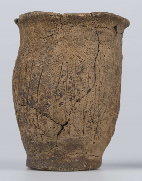 409/A/ML/2 - Naczynie esowate dno płaskie wyraźnie oddzielone brzusiec workowaty szyjka rozchylona pow zewnetrzna przy dnie i wylewie gładzona reszta obmazywana na brzuścu wykonano ostrym narzedziem nieregularne pionowe kreski