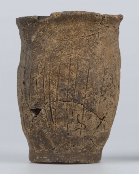 409/A/ML/2 - Naczynie esowate dno płaskie wyraźnie oddzielone brzusiec workowaty szyjka rozchylona pow zewnetrzna przy dnie i wylewie gładzona reszta obmazywana na brzuścu wykonano ostrym narzedziem nieregularne pionowe kreski