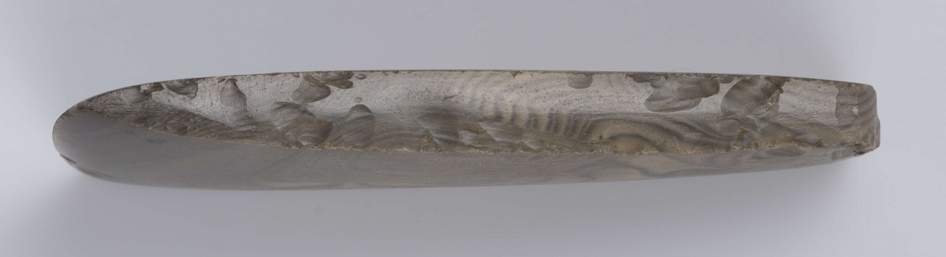 Siekierka czworościenna zwężająca się stopniowo od ostrza ku obuchowi krawędzie boczne proste ostrze łukowate, wszystkie ścianki wypukłe staranie gładzone