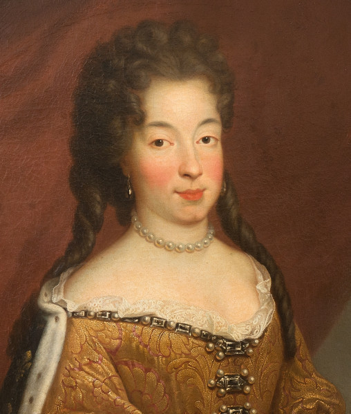 fragment lica obrazu. Popiersie kobiety w złotym gorsecie. Jest zwrócona w lewo. Ciemne oczy kieruje na wprost. Ma jasną cerę, krasne usta i poliki. Włosy upięte z dwoma puklami opadającymi na odkryte ramiona. Na szyi ma krótki sznur pereł, w uszach perłowe łezki, a na plecach płaszcz podbity gronostajem.