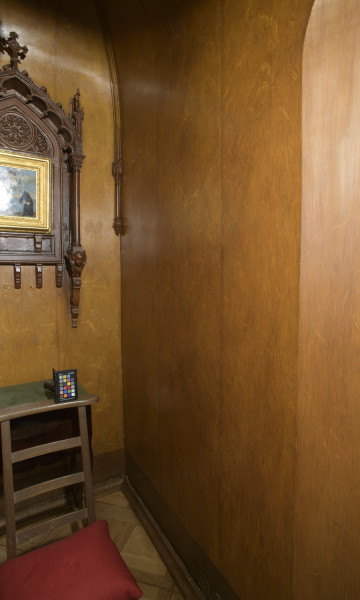 ściana północna, malowana we wzór przypominający drewno, po lewej ołtarzyk na ścianie.