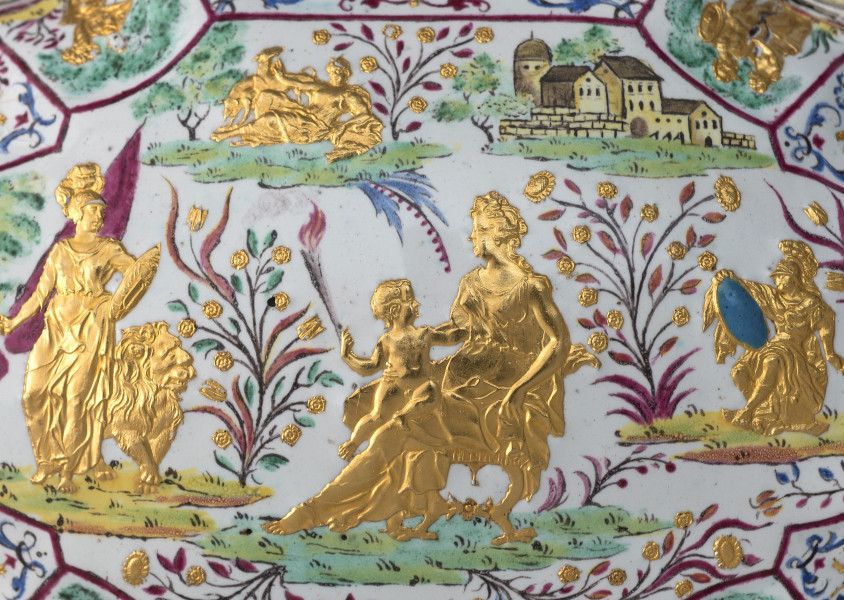 ujęcie z góry - fragment (sceny mitologiczne), pięć złotych postaci, z lewej kobieta ze sztandarem i lwem po środku kobieta siedząca z dzieckiem na kolanach po prawej postać w zbroi z niebieską tarczą, w tle po prawej zabudowania po lewej leżąca postać obok zwierzęta, kwiaty.