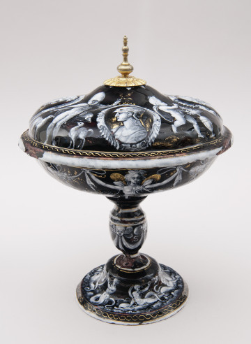 strona pierwsza, ujęcie z boku od góry, na pokrywie dorobiona ze złoconego brązu rozeta ze spiczastym zakończeniem, dekoracja medalion z głową antyczną po bokach dwa amorki, spód czaszy patery zdobią maszkarony połączone draperiami, okrągła nóżka z dekoracją zabawy Najad i Trytonów.