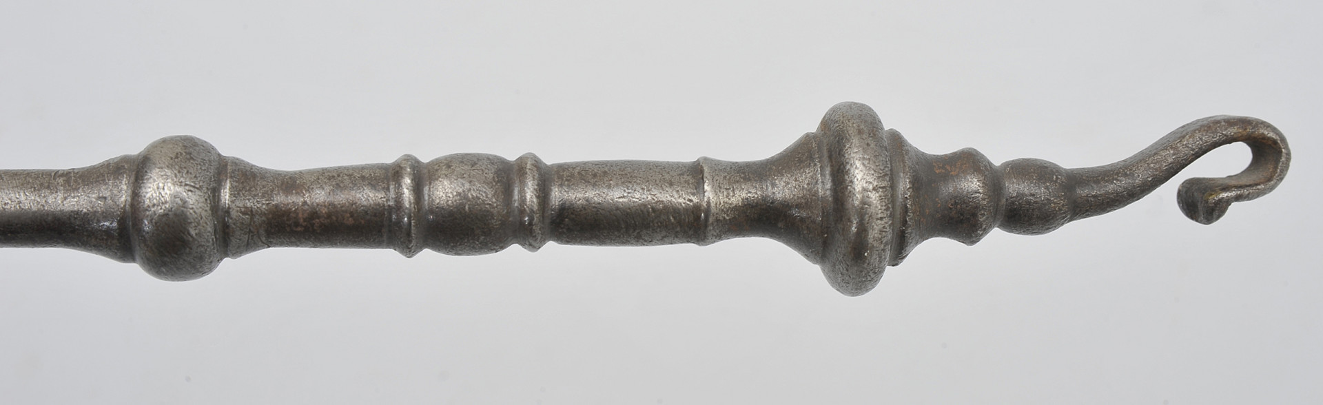 detal - uchwyt. Widok toczonej rączki, zakończonej wydatnym pierścieniem za którym znajduje się haczyk do odwieszania.