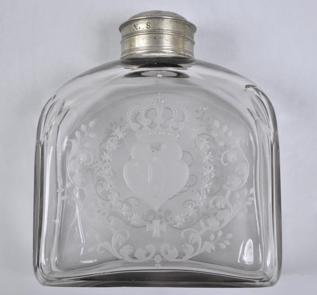 strona pierwsza, Widoczna szersza ścianka o łukowatym zasklepieniu. Centralnie jest umieszczona kompozycja herbowa. Herb Janina jest na matowym, ukoronowanym polu, w formie zbliżonej do serca. Otacza go łańcuch orderu Św. Ducha i wieniec roślinny.