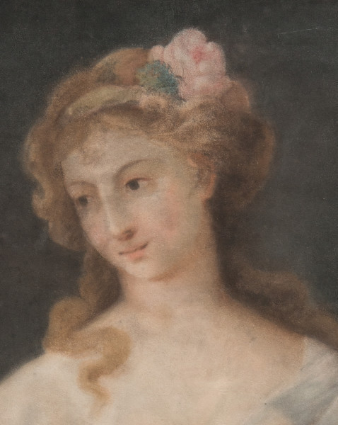 fragment lica obrazu. Popiersie na szarym tle. Dziewczę o alabastrowej cerze. Przechylona głowa i ciemne oczy skierowane w prawo. Ma odkryte ramiona i delikatne rysy. Jasne fale włosów są swobodnie upięte i przyozdobione bladą różą z listkiem.