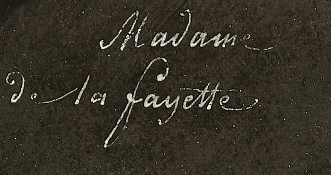 Fragment lica obrazu - napis białą farbą, kursywą: Madame de La Fayette. Tło ciemno-brązowe.