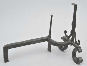 Ujęcie 3/4. Widok z boku, lekko z tyłu i od góry, z przodem po prawej stronie. W większości pręt prosty, bliżej przodu wygięty w prawo. W miejscu wygięcia smukły szpikulec. Pręt łączy się z przednią częścią obiektu przy metalowej płytce. Powyżej niej pionowy trzpień. Poniżej zwężenia na trzpieniu odchodzą dwa wygięte ramiona. Od płytki odchodzą wygięte stopki. Obiekt w całości czarny, lekko błyszczący.