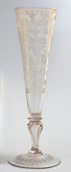 strona pierwsza. Smukły kielich, lejkowato rozszerza się ku górze. Na okrągłej stopie umieszczony delikatny wieniec z podłużnymi liśćmi. Wyżej tralkowata nóżka łączy stopę z czaszą. Na czaszy występuje bogata dekoracja: spiralnie biegnąca gałązka winnej latorośli.