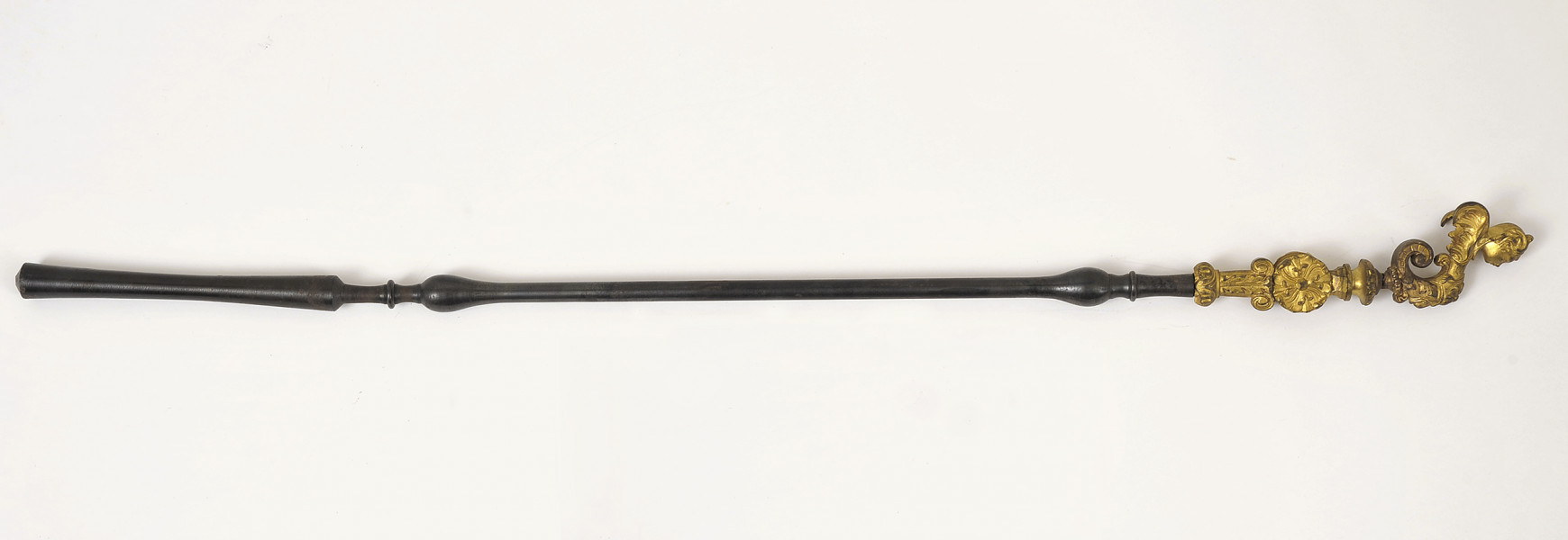 Strona prawa. Obiekt ustawiony poziomo, z rękojeścią po prawej stronie i frontem skierowanym w dół. Rękojeść bogato zdobiona w kolorze złotym. Pozostała część rozbijaka jest czarna.