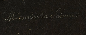 Fragment lica obrazu - napis białą farbą kursywą: Madame de la Sablliere. Tło ciemnobrązowe.