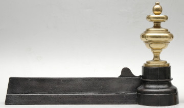 strona pierwsza. Czarna żelazna listwa zajmuje całą dolną część kadru. Po prawej stronie jest zakończona sterczyną z polerowanego, jasnożółtego metalu. Sterczyna jest toczona, okrągła w przekroju, z wyraźnymi przewężeniami u góry i u dołu oraz jajowatą gałką u góry.