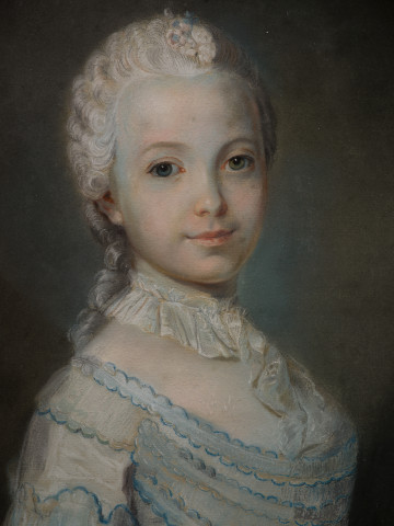 lico obrazu. Popiersie dziewczynki o alabastrowej cerze. Ujęcie trzy czwarte w lewo. Głowę i duże oczy kieruje na wprost. Jest w pudrowanej peruce z wpiętym bukiecikiem kwiatów. Ubrana w białą suknię z niebieskimi wstążkami. Wokół szyi koronka, której koniec jest wpuszczony w dekolt.