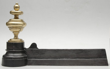 strona trzecia. Czarna żelazna listwa zajmuje całą dolną część kadru. Po lewej stronie jest zakończona sterczyną z polerowanego, jasnożółtego metalu. Sterczyna jest toczona, okrągła w przekroju, z wyraźnymi przewężeniami u góry i u dołu oraz jajowatą gałką u góry.
