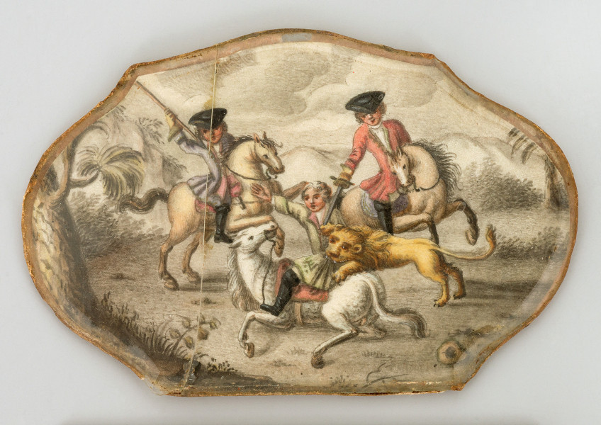 miniatura na papierze pod szkłem na wewnętrznej stronie pokrywki pudełka przedstawiająca scenę myśliwską: dwaj jeźdźcy na koniach, trzecia postać na ziemi atakowana przez lwa, poniżej leżący koń. W tle góry, po lewej fragment drzewa.