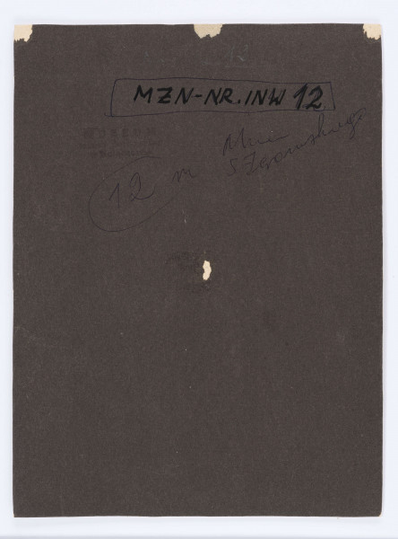 Głowa lekko skręcona w prawo, z opaską na głowie, w kamizelce, bluzka z broszką pod szyją.