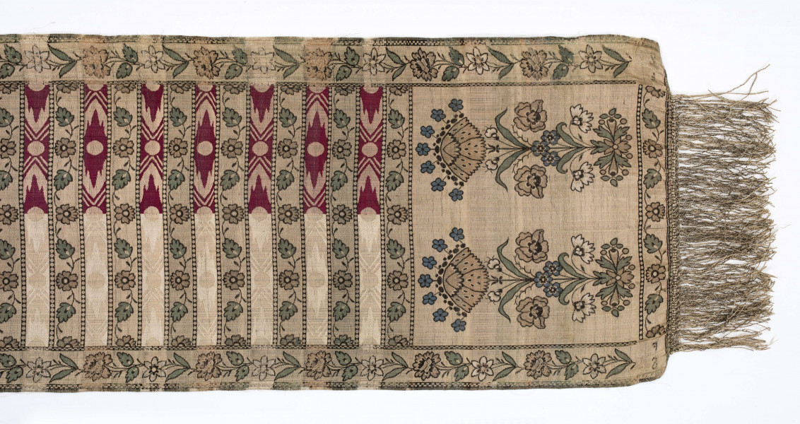 Pas kontuszowy czterostronny
Ornament: 
głowy - dwa motywy krzaczków kwiatowych wyrastających z liściastej rozety
środek - poprzeczne pólka na przemian z motywami wici kwiatowej i wydłużonych rombów z szelążkami
obrzeżenia - pionowe z motywami gałązek z kawiatami i liśćmi; poziome - motywy wici kwiatowej jak w pólkach
obwódki - w szachownicę, romby i groszki
Koloryt:
pr. - tło słomkowe, ornament różowy, biały, zielony, błękitny, jaznobrązowy
l. - tło czarne, jedynie w pólkach z rombamiw połowie błękitne, w połowie oliwkowozłote, ornament słomkowy
W narożnikach głów wytkana sygnatura: F/S (leżące)
Frędzla doszyta jedwabna, pleciona z nici kremowych z dodatkiem czarnych
