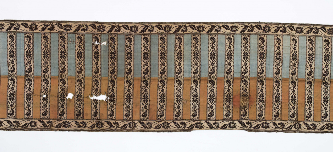 Pas kontuszowy czterostronny
Ornament
Głowy- motyw dwóch drzewek, których koronę stanowi owalna rozeta otoczona listkami, rozeta i listki wypełnione małymi kwiatkami. Drzewko wyrasta z lekko pofalowanego gruntu po bokach dwa małe krzaczki kwiatowe. 
Wciąż- pasa w poprzeczne pólka na przemian gładkie i z motywem wici kwiatowej.
Obrzeżenia- pionowe z motywem wici złożonej z kwiatów i listków palmowych, poziome jak w  pólkach.
Kolory: karmazynowy, błękitny, zielony, kremowy i brązowy
Pas sygnowany- w głowach tkany napis: S Filsjean Wkobyłce
Krótsze boki z doszytą długą frendzlą