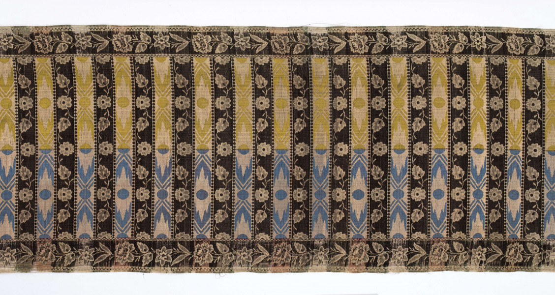 Pas kontuszowy czterostronny
Ornament: 
głowy - dwa motywy krzaczków kwiatowych wyrastających z liściastej rozety
środek - poprzeczne pólka na przemian z motywami wici kwiatowej i wydłużonych rombów z szelążkami
obrzeżenia - pionowe z motywami gałązek z kawiatami i liśćmi; poziome - motywy wici kwiatowej jak w pólkach
obwódki - w szachownicę, romby i groszki
Koloryt:
pr. - tło słomkowe, ornament różowy, biały, zielony, błękitny, jaznobrązowy
l. - tło czarne, jedynie w pólkach z rombamiw połowie błękitne, w połowie oliwkowozłote, ornament słomkowy
W narożnikach głów wytkana sygnatura: F/S (leżące)
Frędzla doszyta jedwabna, pleciona z nici kremowych z dodatkiem czarnych
