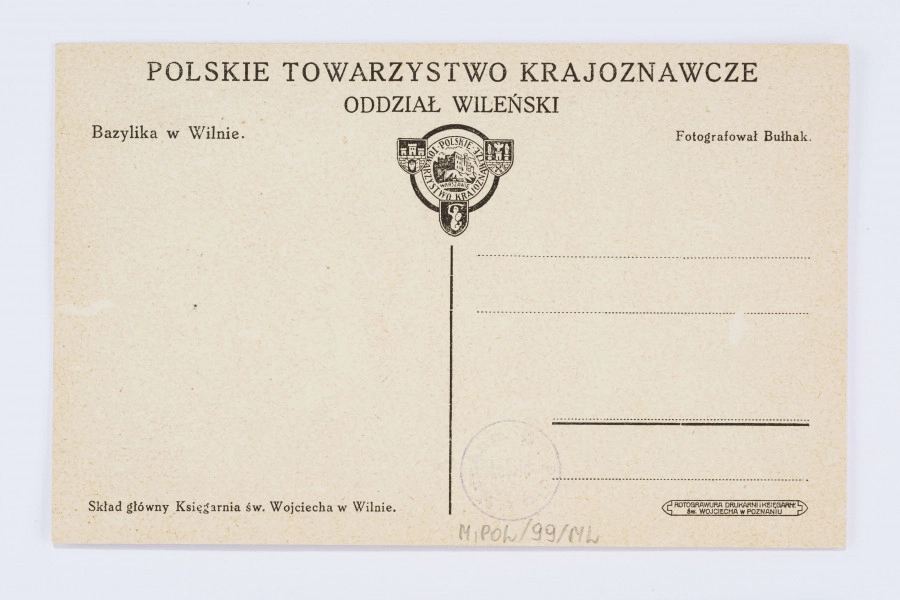 Pocztówka wykonana w sepii, przedstawia Bazylikę św. Stanisława i św. Władysława w Wilnie: budynek na planie prostokąta, z kolumnadą po boku, zwięczony dwoma kopułami z wieżyczkami. Przed bazyliką pusty plac z kilkoma sylwetkami ludzi w czerni. Po lewej stronie wieża otoczona bezlistnymi drzewami.