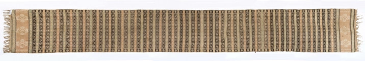 Pas kontuszowy dwustronny.
Ornament: 
głowy-trzy motywy stylizowanego kwiatu  goździka (każdy o czterech zgeometryzowanych płatkach)
wciąż pasa- poprzeczne pólka o kolejnych powtarzajacych się sekwencjach motywów:
-ciąg palmetek
-stylizowane kwiaty na tle łososiowym
-stylizowane kwiaty na tle zielonm
obrzeżenie- nieznacznie wyodrebnione dekorowane rozetką
Frędzla wysnuta z osnowy